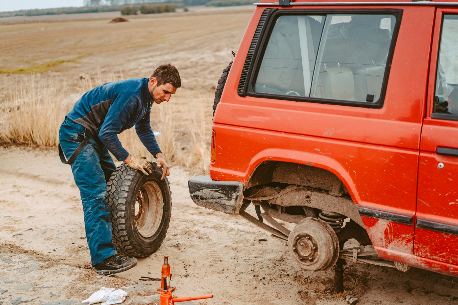 professional mechanic fixing jeep's tyre.